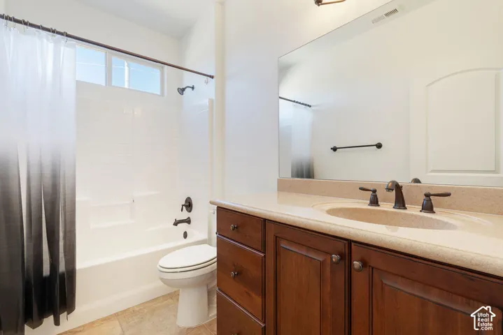Wood-finish vanity with integrated sink, bronze-finish faucet, and a large wall-mounted mirror
