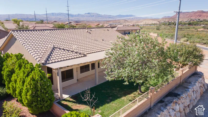 Rear exterior featuring a covered patio, a tiled roof, and a walled yard