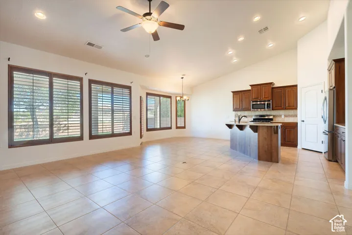 Spacious interior with tile flooring, vaulted ceilings, and recessed lighting