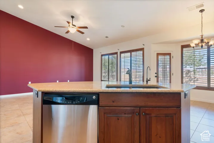 Kitchen island with a built-in stainless steel dishwasher, an undermount sink, and a high-arc faucet