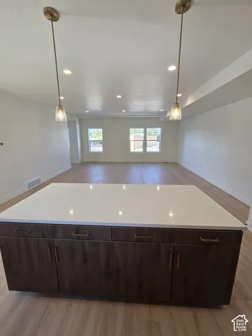Expansive central island featuring a light-toned countertop and wood-finish cabinetry