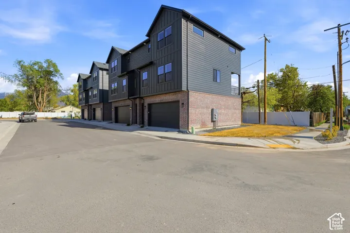 Modern townhome architecture featuring dark gray siding and brick facade