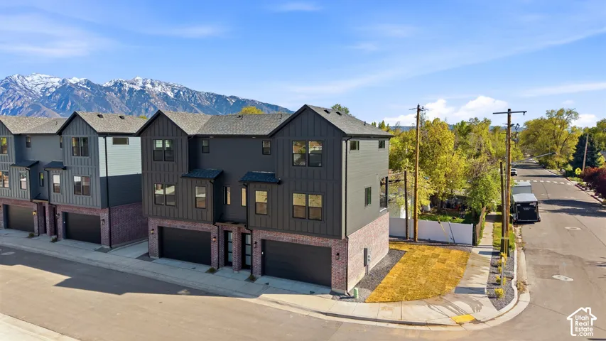 Modern townhome featuring dark vertical siding and brick accents