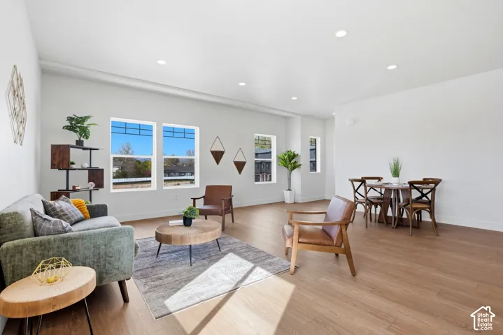 Recessed lighting illuminating a spacious room with wood-finish flooring