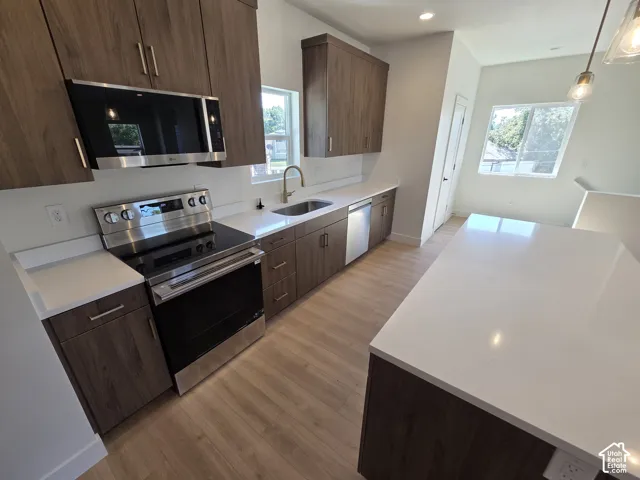Wood-finish cabinetry paired with light-toned countertops and wood-finish flooring