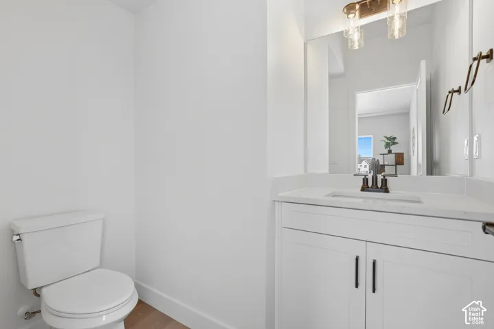 White vanity with shaker-style cabinetry, a solid surface countertop, and a rectangular undermount sink