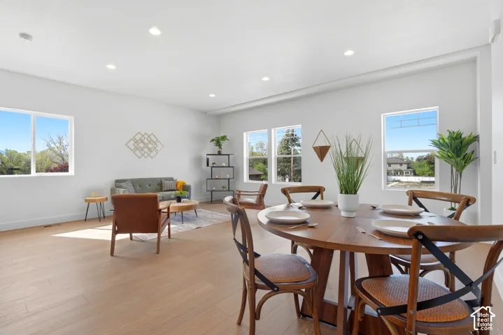 Open concept living area with wood-finish flooring, recessed lighting, and multiple windows