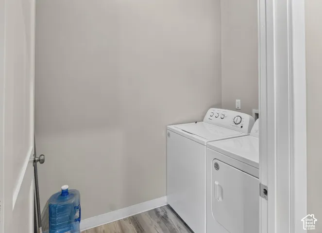 Dedicated laundry area featuring wood-finish flooring