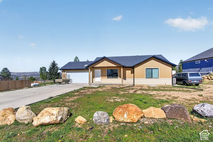 Single-story residence featuring stucco and stone veneer exterior, an attached two-car garage, and a concrete driveway
