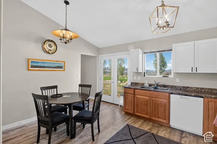 Kitchen with wood-finish flooring, two-tone cabinetry, recessed sink, and a built-in dishwasher