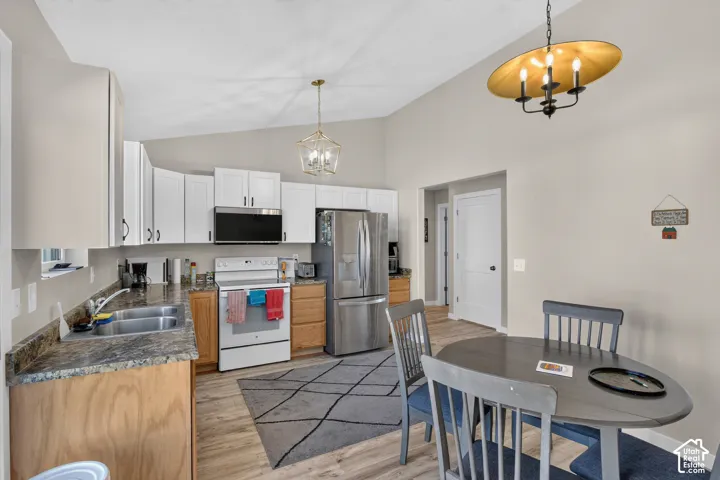 Kitchen featuring white upper cabinetry, wood-finish lower cabinetry, and stainless steel appliances