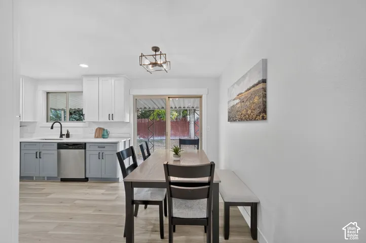 Kitchen featuring white upper cabinetry, gray lower cabinetry, and a stainless steel dishwasher
