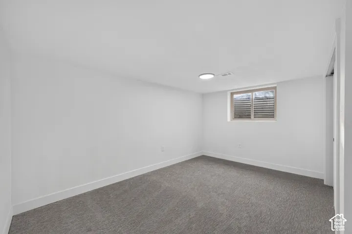 Recessed window, gray carpeting, neutral wall paint, and overhead lighting