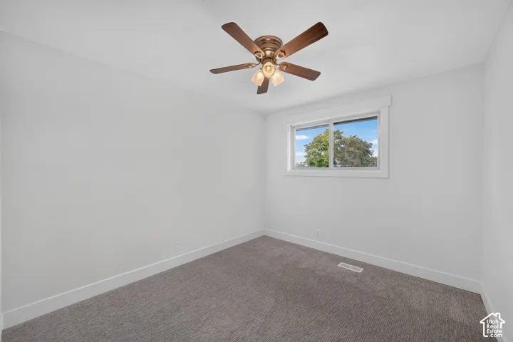 Recessed ceiling fan with integrated lighting, window with exterior scenery, and light gray wall-to-wall carpeting