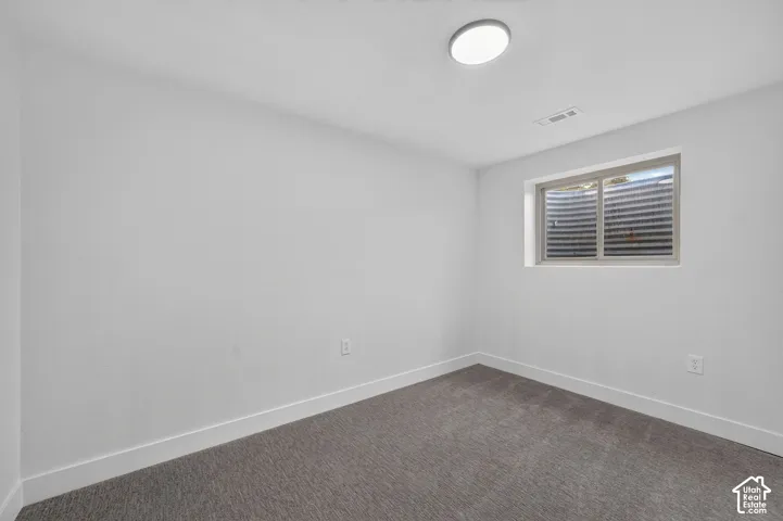 Carpeted flooring, egress window, white walls, recessed ceiling lighting