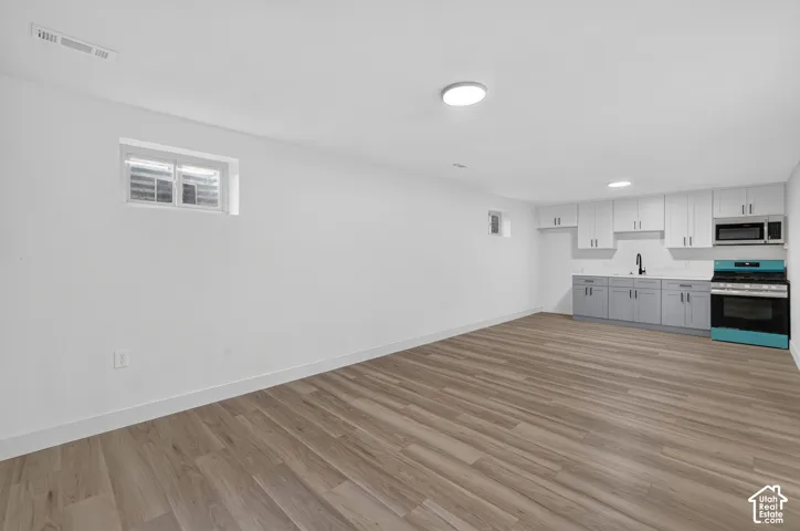 Wood-finish flooring throughout, white walls, and a recessed window