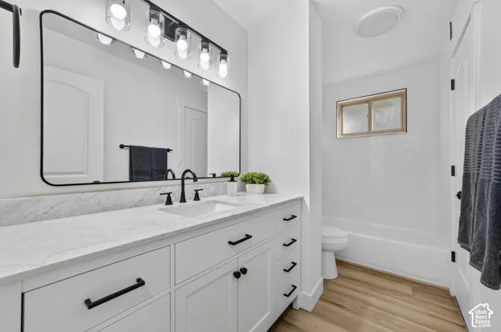 Spa-inspired primary bathroom showcasing a white vanity with dual sinks, brushed nickel hardware, and a marble-look countertop