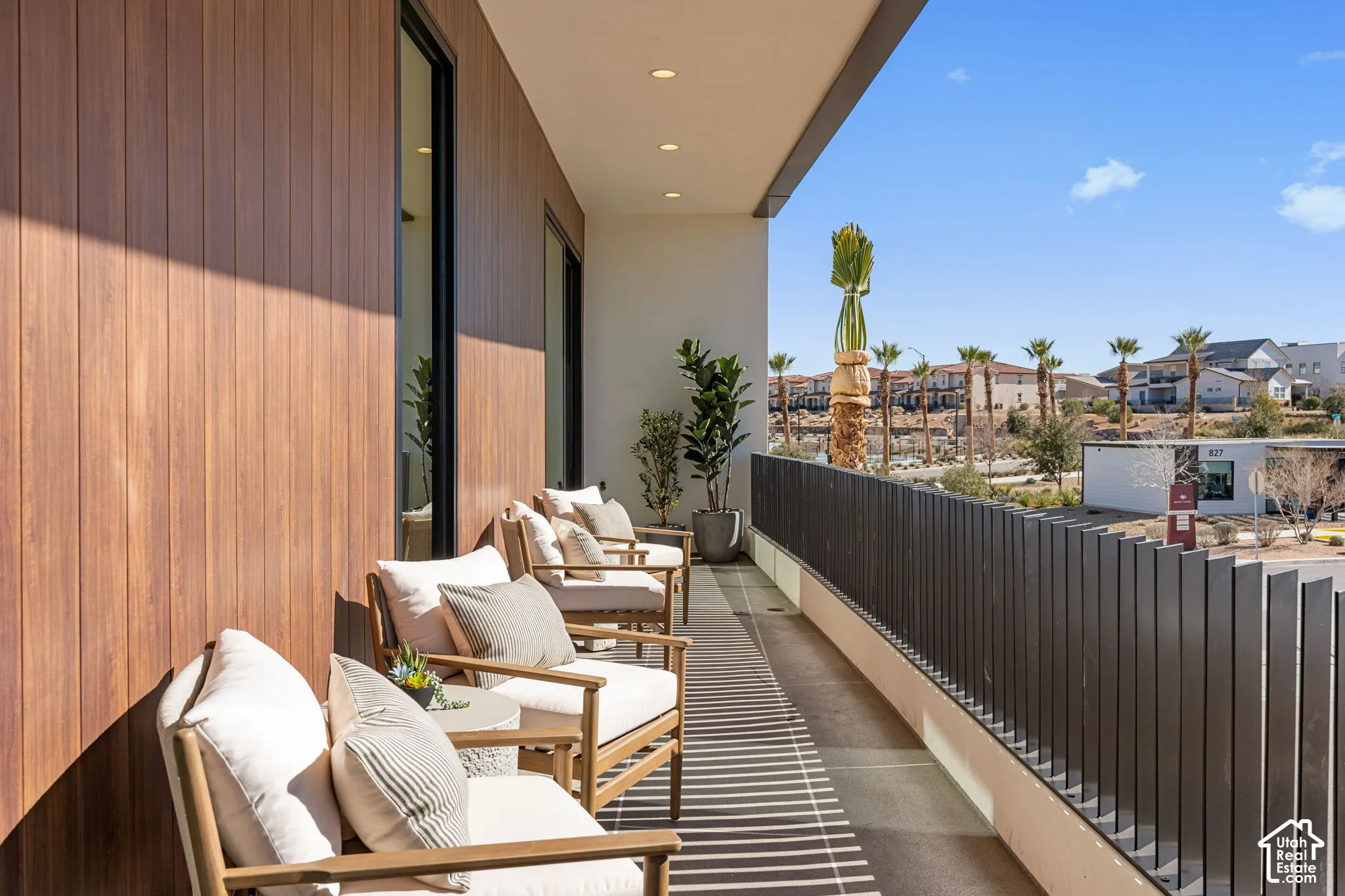 Expansive balcony featuring wood-finish wall paneling and a dark-toned metal railing