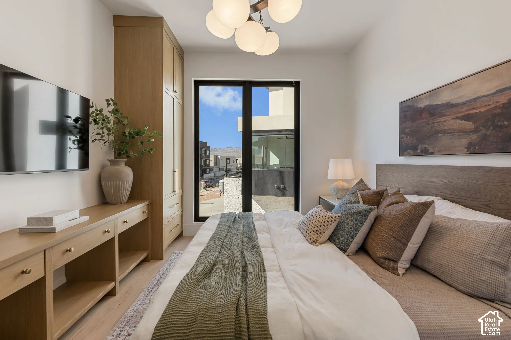 Built-in wood-finish cabinetry, black-framed floor-to-ceiling window, wood-finish flooring, recessed wall niche, and modern ceiling light fixture