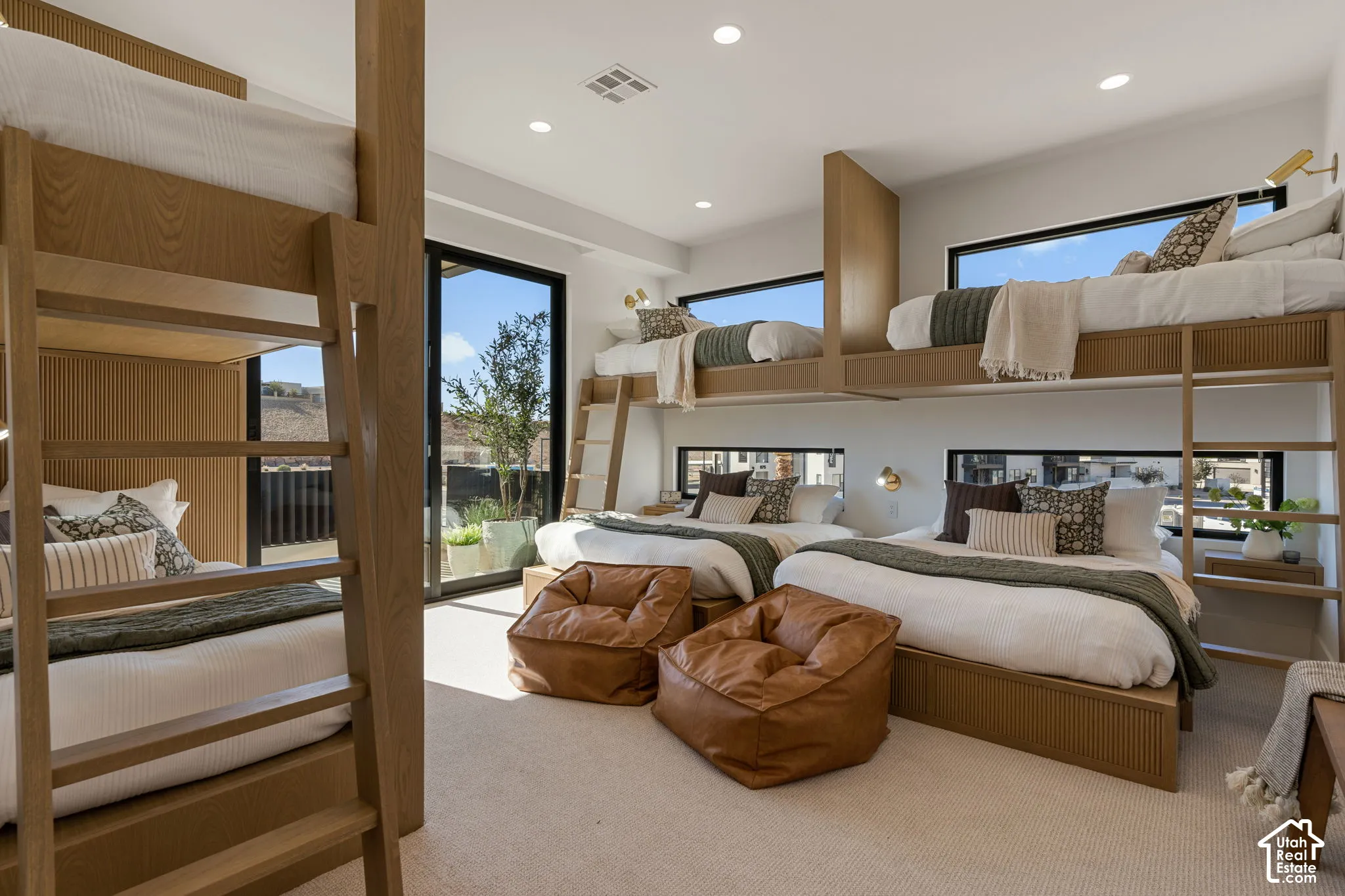 Built-in bunk beds with integrated ladders, large sliding glass door, recessed lighting, and wall-mounted sconces