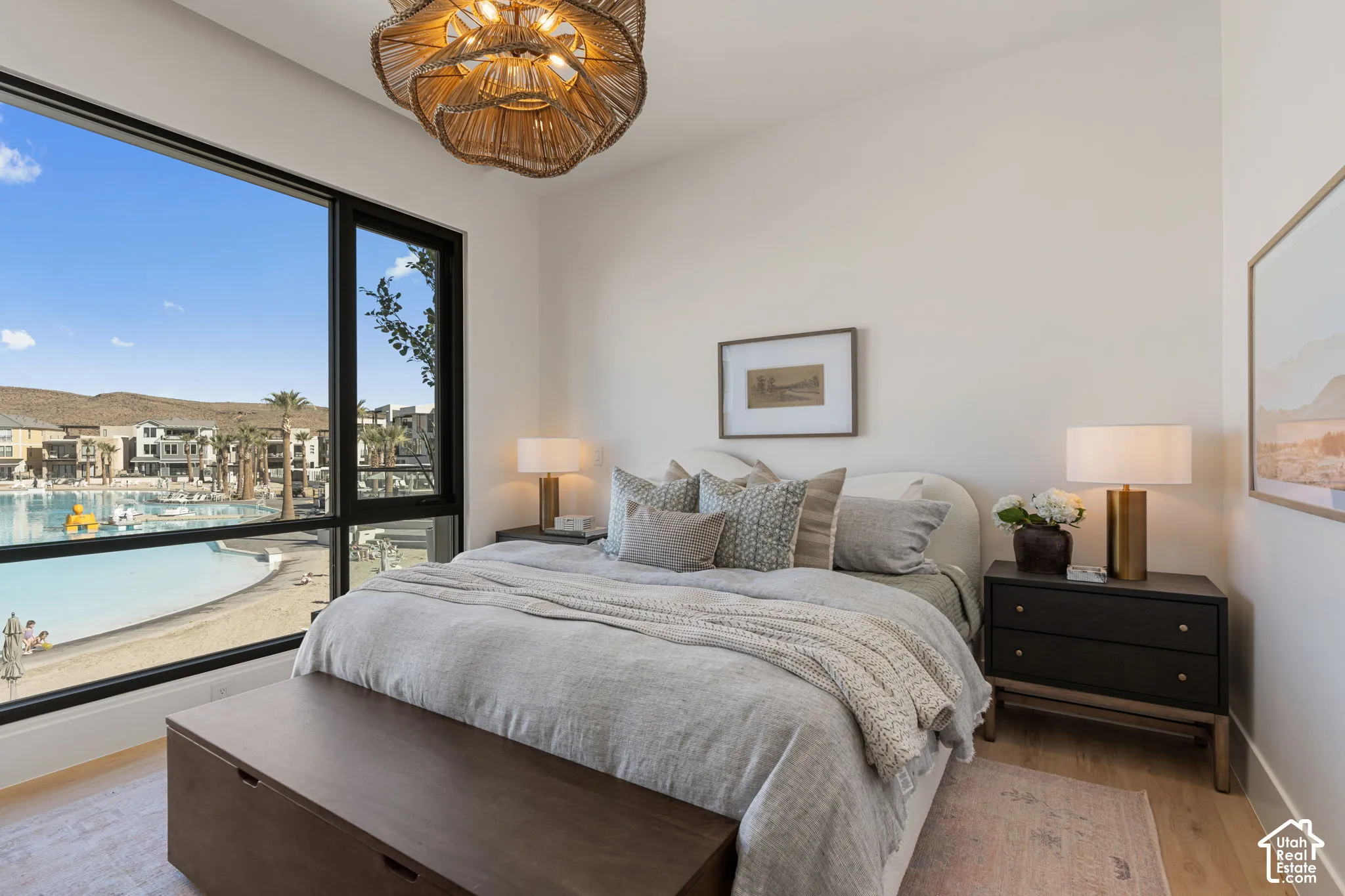 Expansive window with black framing, wood-finish flooring, a textured ceiling light fixture, and light-toned walls