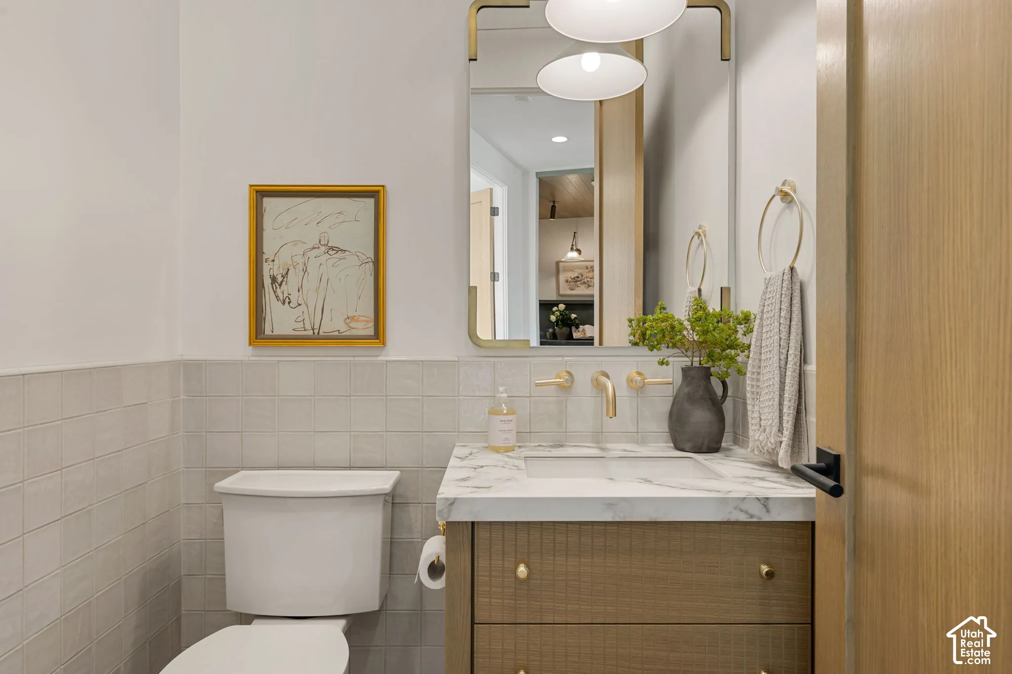 Wood-finish vanity with a stone countertop and integrated sink