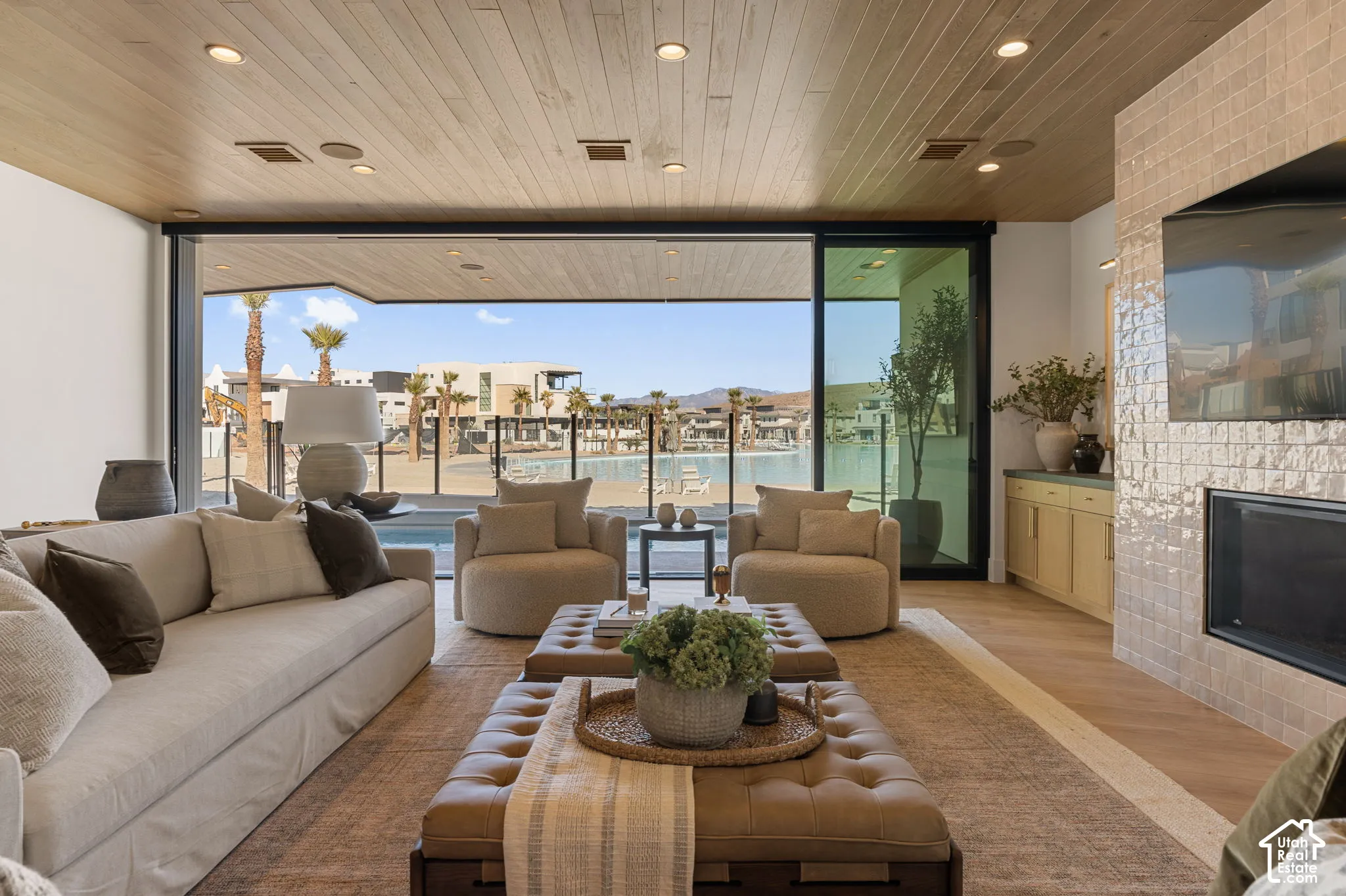 Wood-finish ceiling with recessed lighting, large sliding glass doors, built-in fireplace with tile surround, wood-finish flooring, and built-in cabinetry with countertop