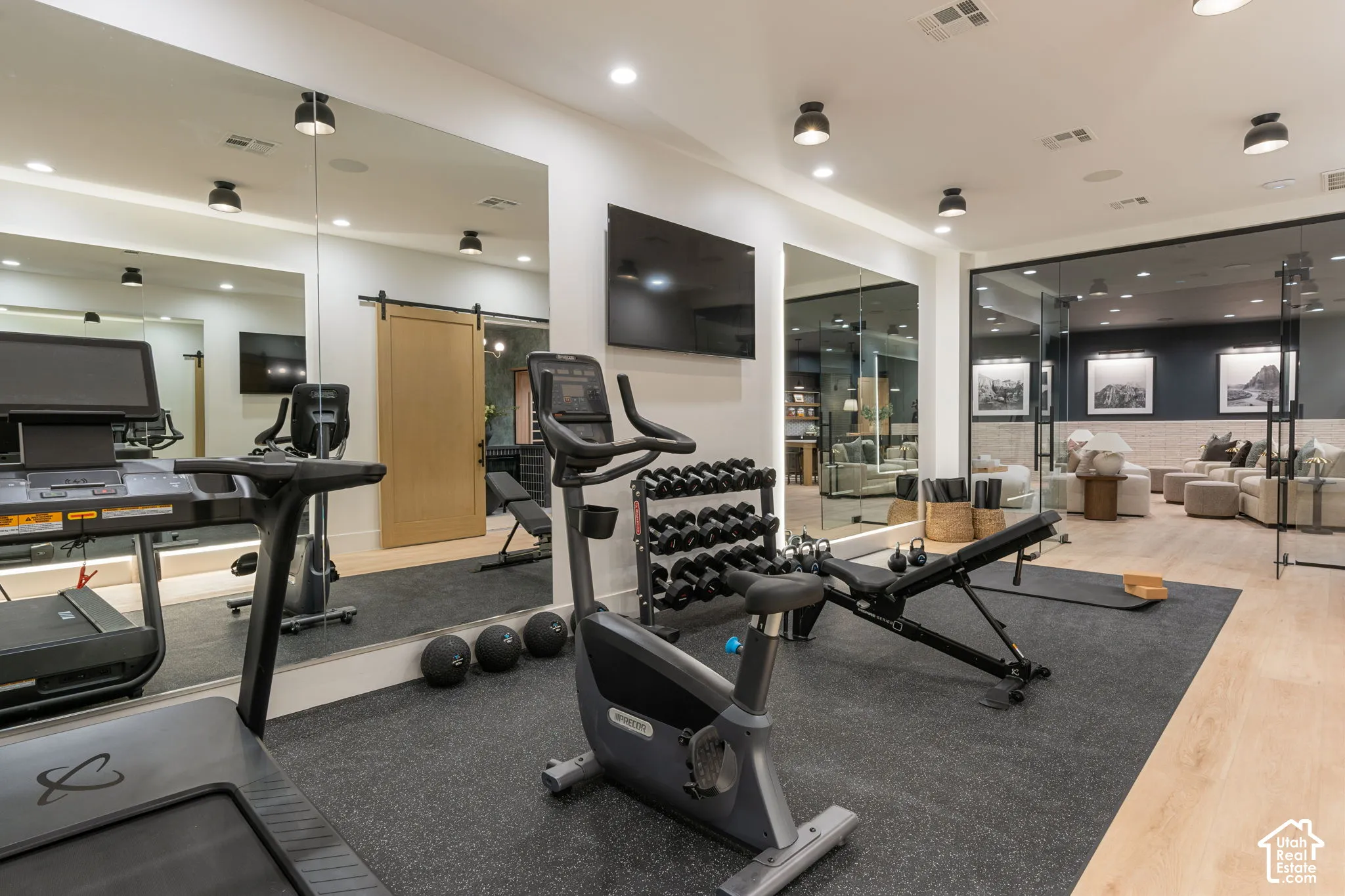 Dedicated fitness area featuring a rubberized floor and full-wall mirrors