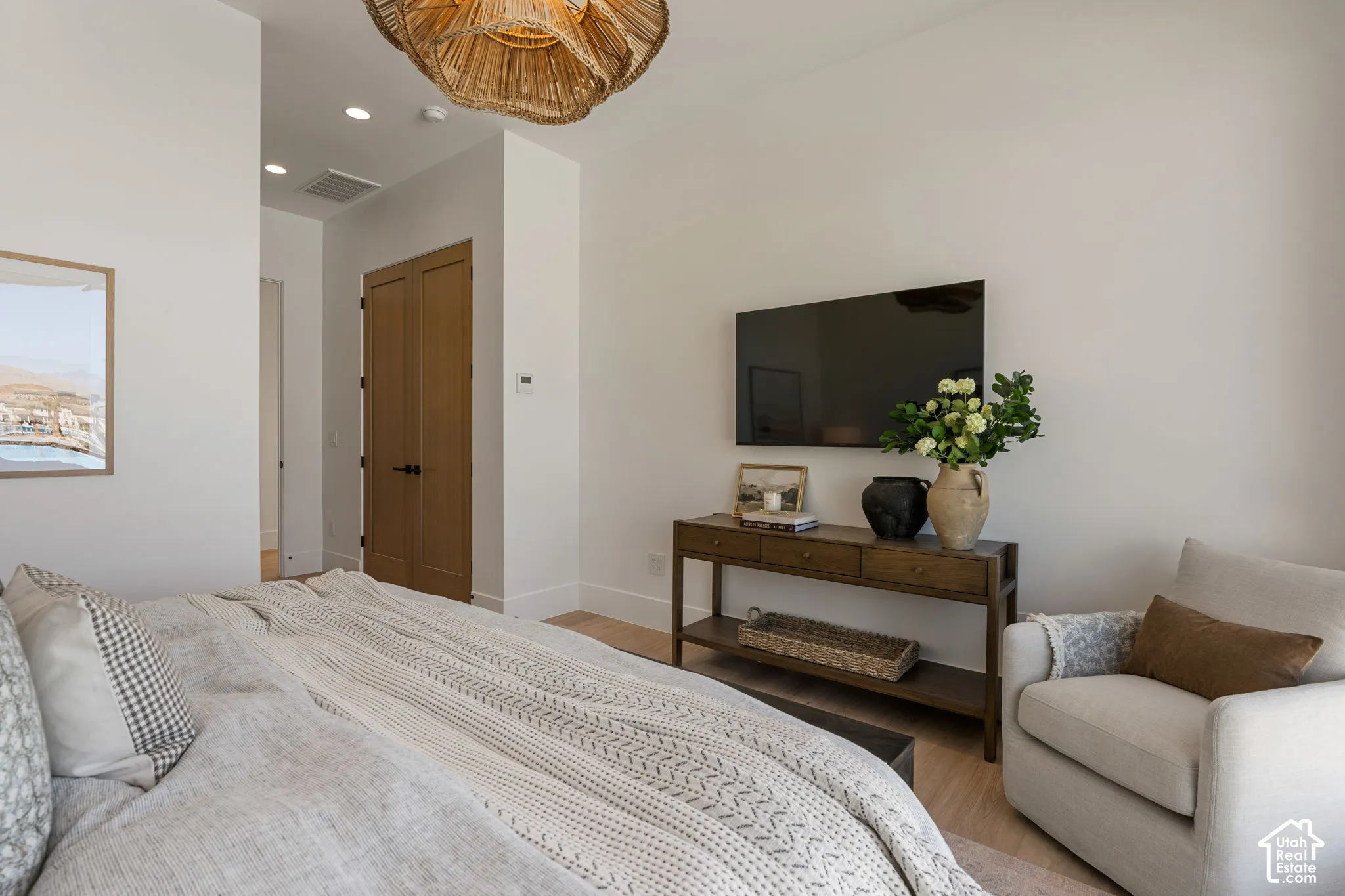 Light wood-finish flooring, recessed lighting, and a woven ceiling fixture