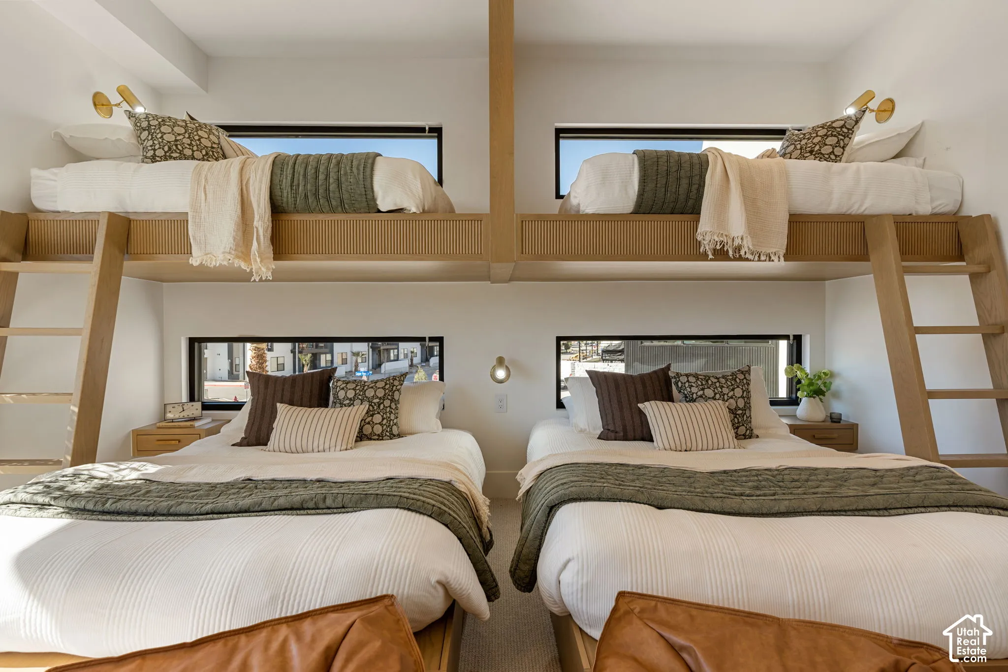 Built-in bunk beds with integrated ladders, individual windows, and wall-mounted sconces