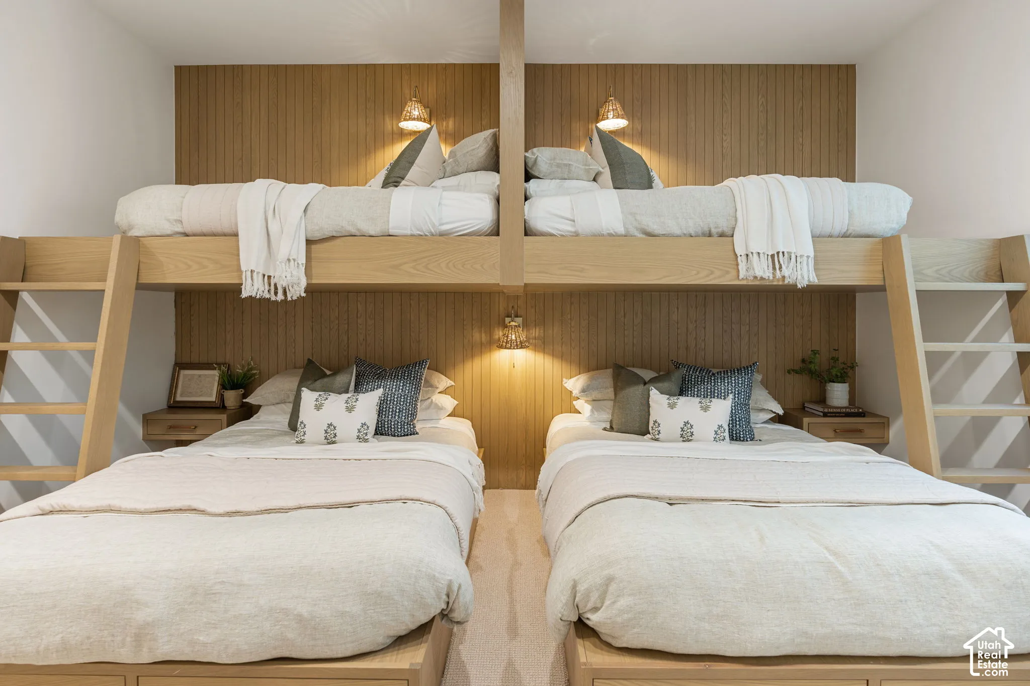 Built-in bunk beds with integrated ladders, wood-finish paneling, and wall-mounted sconces