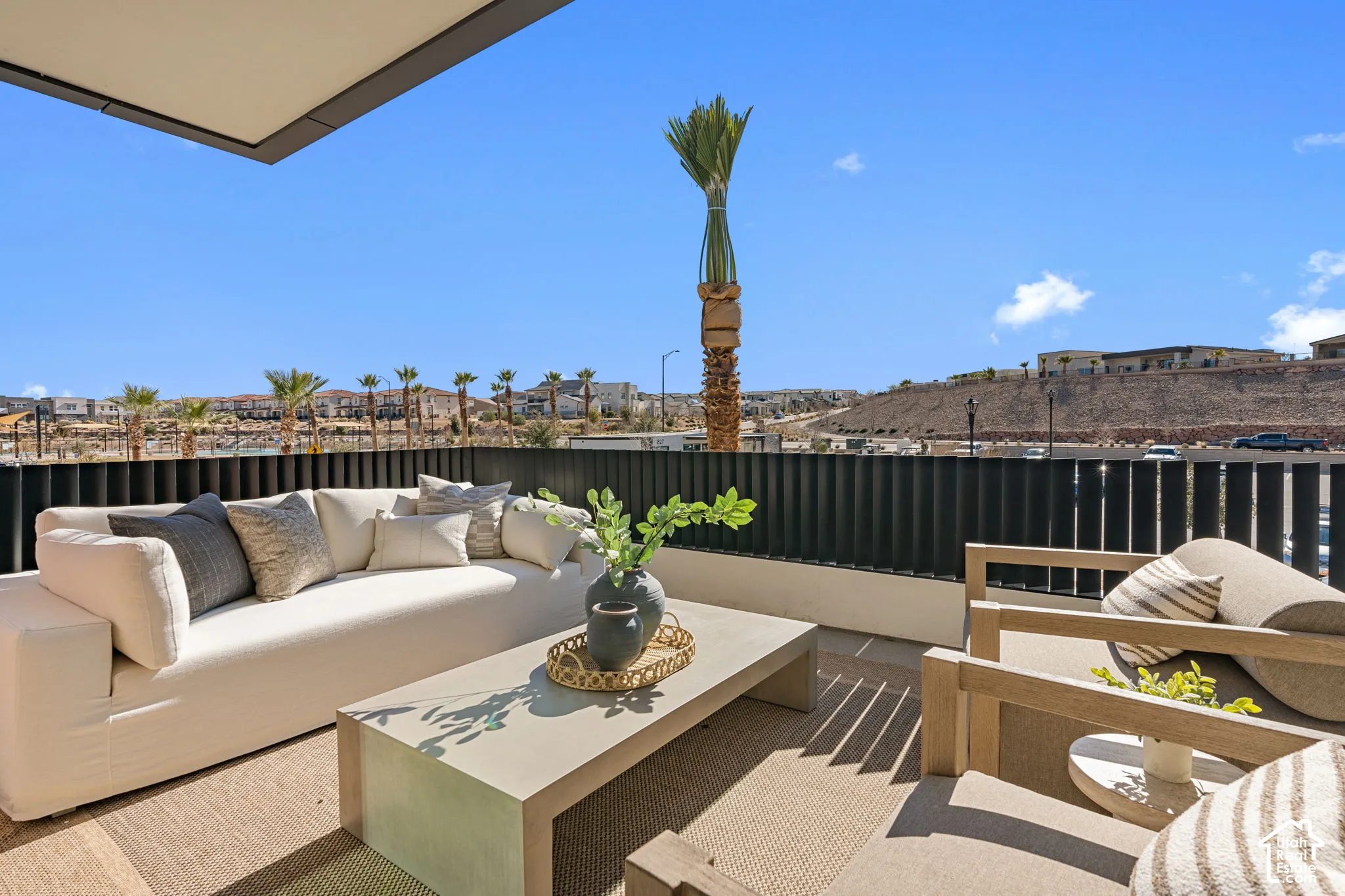 Outdoor patio featuring a concrete hardscape, a contemporary privacy fence, and an overhead architectural element