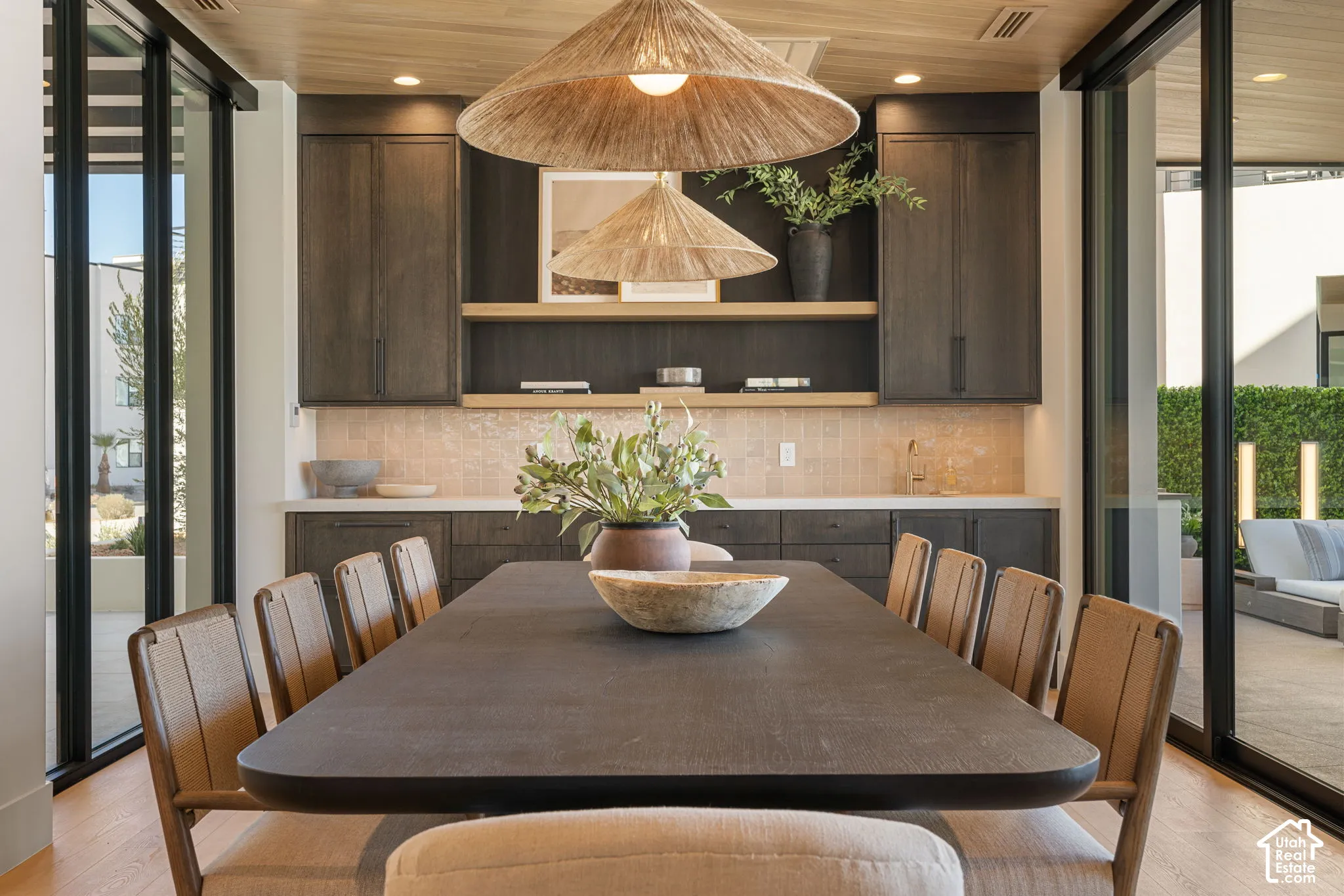 Recessed lighting with wood-finish ceiling, dark wood-finish cabinetry, light tile backsplash, and oversized glass sliding doors