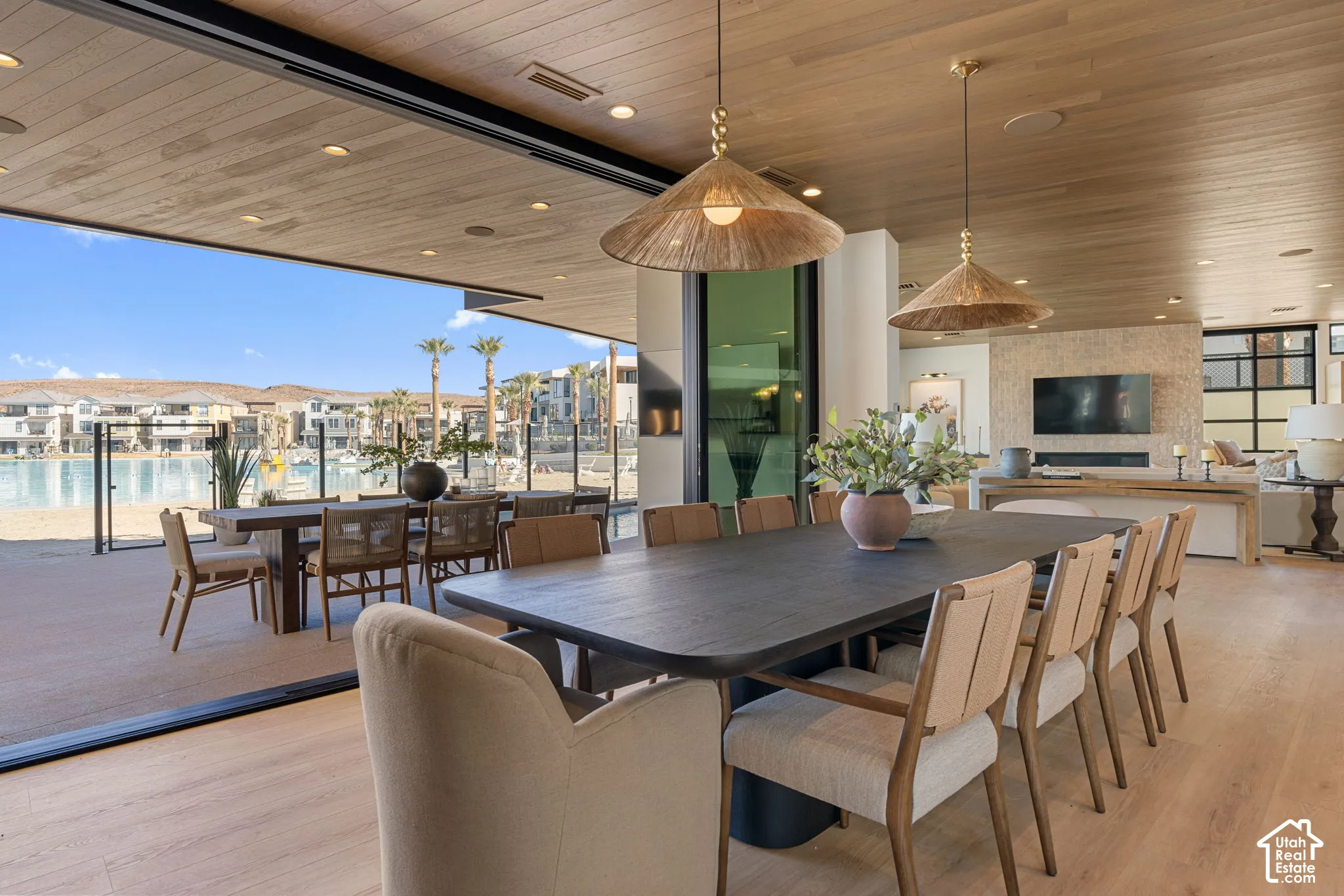 Expansive sliding glass doors, wood-finish flooring, recessed lighting, wood-paneled ceiling, and a built-in fireplace feature