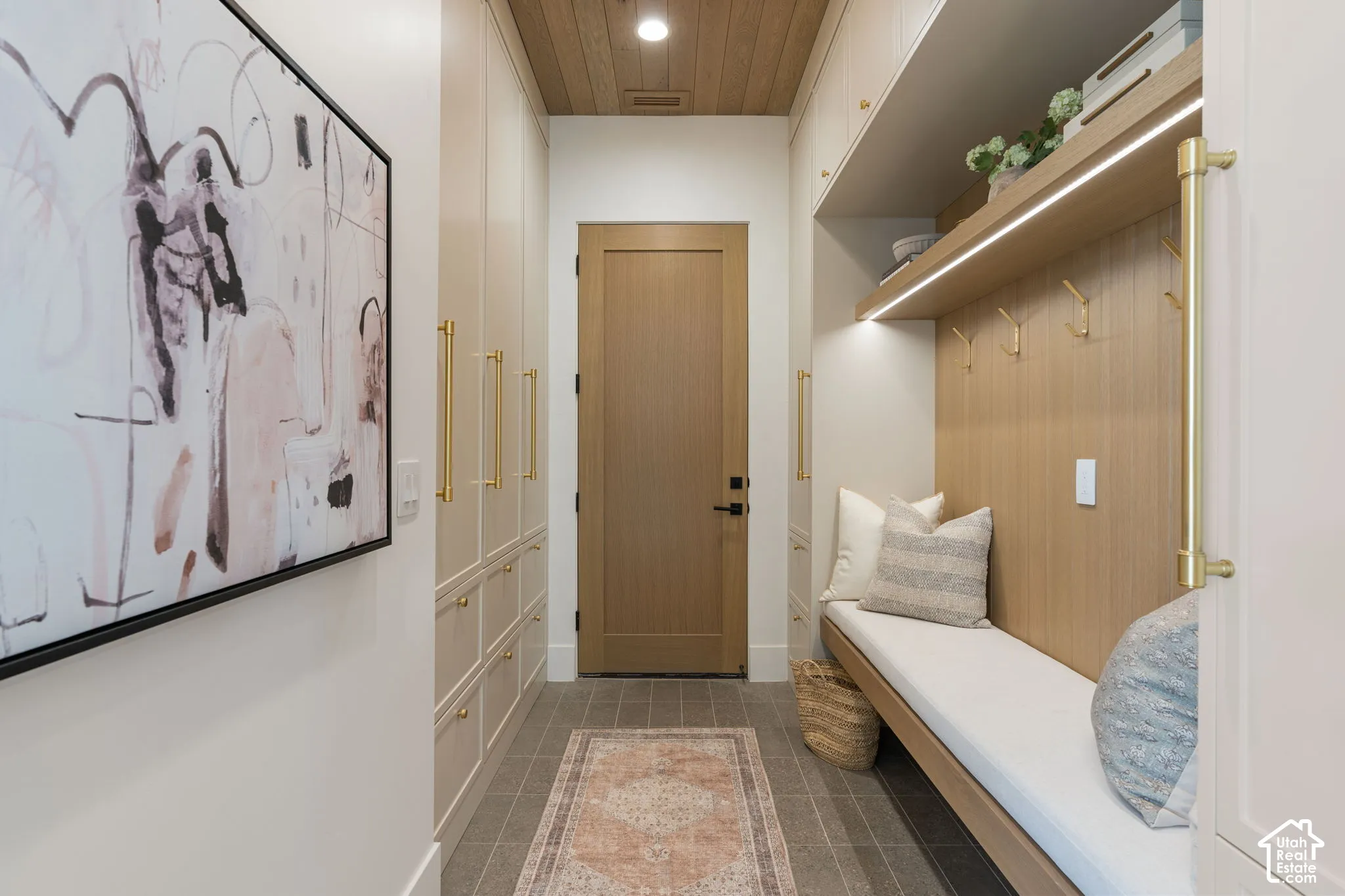 Built-in bench with storage, wood paneling, recessed lighting, integrated shelving, and large format floor tile