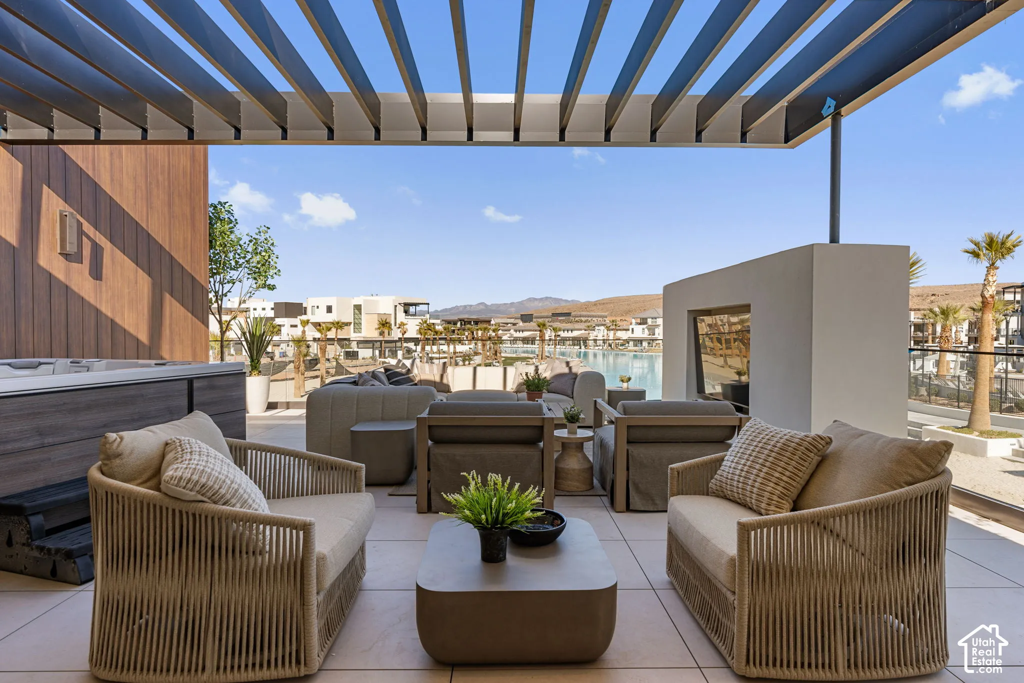 Spacious outdoor patio with a louvered pergola, built-in hot tub, and a decorative fireplace