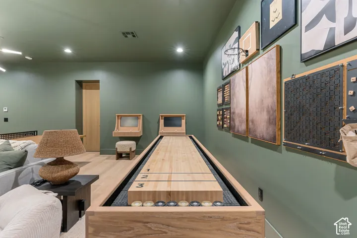 Wood-finish flooring, recessed lighting, and a shuffleboard table with scoring marks