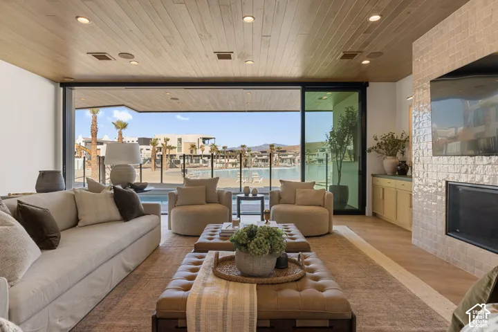 Wood-finish ceiling with recessed lighting, large sliding glass doors, built-in fireplace with tile surround, wood-finish flooring, and built-in cabinetry with countertop