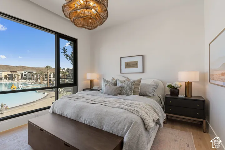 Expansive window with black framing, wood-finish flooring, a textured ceiling light fixture, and light-toned walls