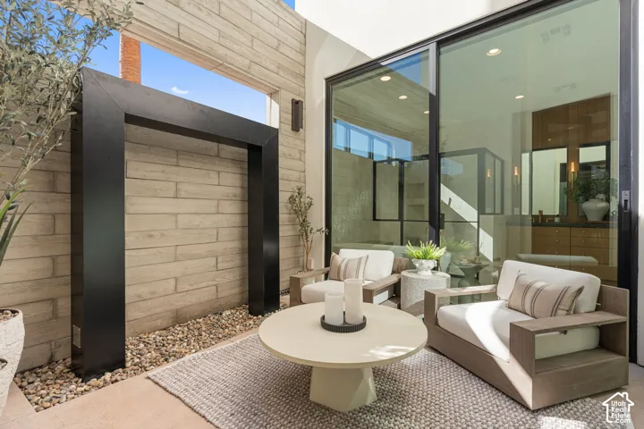 Private outdoor patio featuring a concrete paver floor and a stone-clad wall