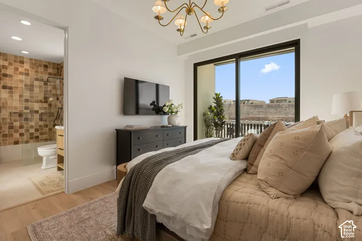 Sliding glass doors, wood-finish flooring, recessed lighting, brass chandelier, and a tiled bathroom with a glass-enclosed shower