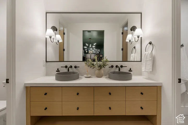 Dual vessel sinks with wall-mounted matte black faucets, set within a light-toned countertop