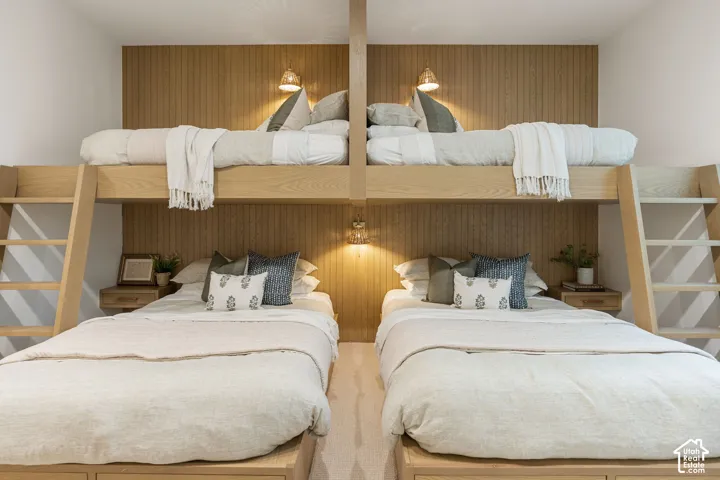 Built-in bunk beds with integrated ladders, wood-finish paneling, and wall-mounted sconces
