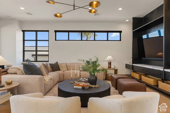 Integrated shelving with a light-toned countertop, recessed lighting, and a contemporary linear chandelier