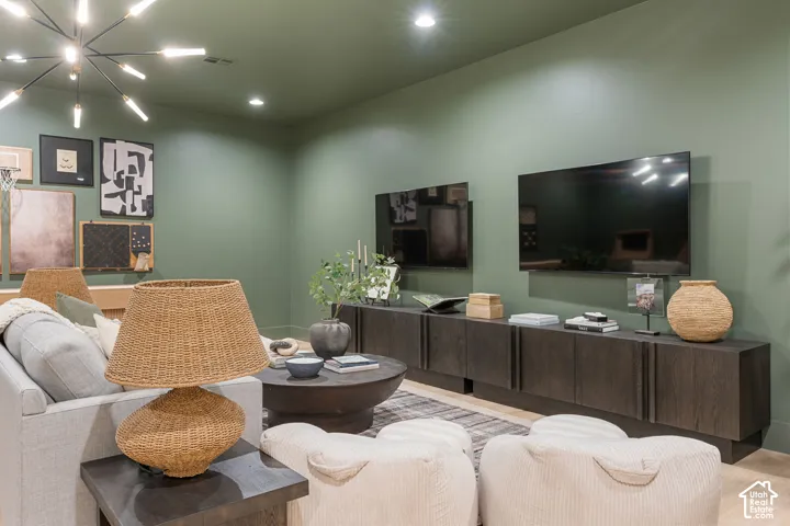 Recessed lighting illuminates the ceiling, complementing the modern chandelier