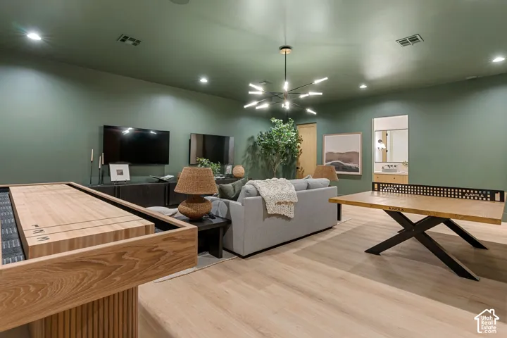 Recessed lighting, wood-finish flooring, accent wall, modern light fixture, built-in vanity
