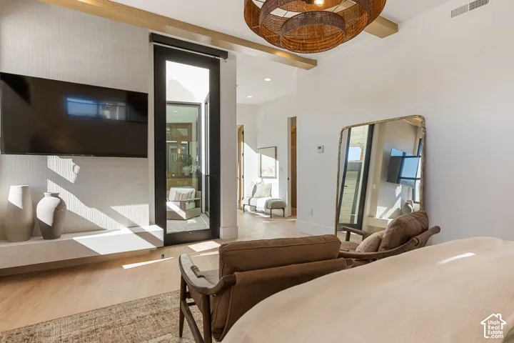 Wood-finish flooring, exposed ceiling beams, and a black-framed glass door
