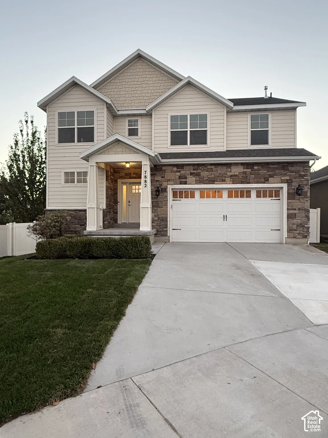 Two-story exterior with light-toned siding and stone accents