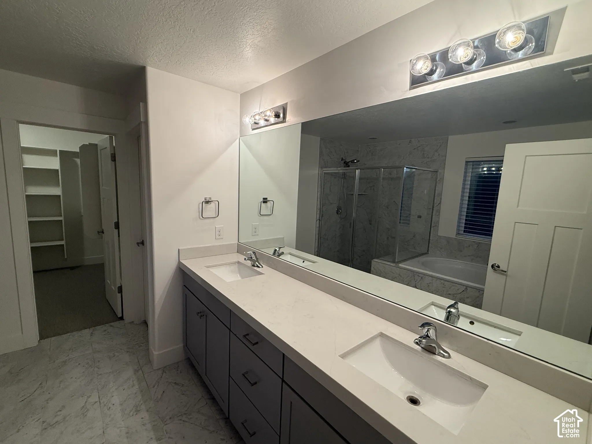Double vanity with light countertops, undermount sinks, and chrome fixtures