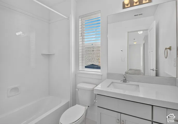 White vanity with a rectangular undermount sink, a chrome faucet, and a large wall-mounted mirror